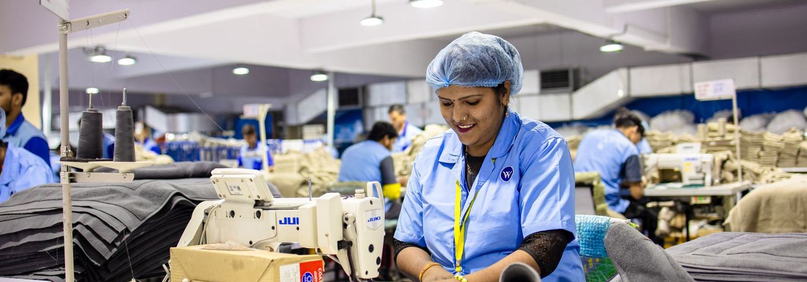 Garment workers at cutting and sewing tables on the production floor